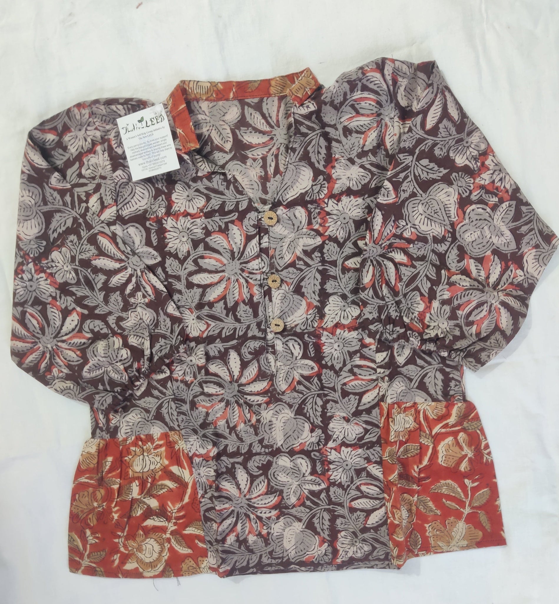 Floral patterned shorts with a tag on a white surface